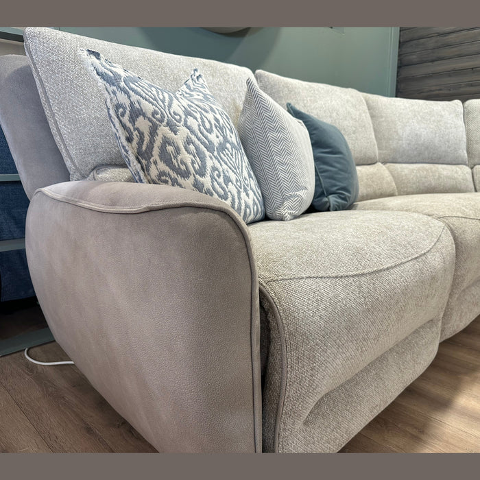 A close-up of the Willow Corner, featuring easy-clean upholstery and adorned with decorative pillows in assorted blue and gray patterns, set atop a wooden floor in a modern living room.