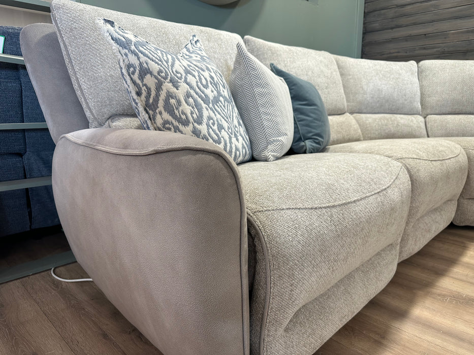 A close-up of the Willow Corner, featuring easy-clean upholstery and adorned with decorative pillows in assorted blue and gray patterns, set atop a wooden floor in a modern living room.
