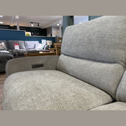 Close-up of a light gray easy-clean fabric sofa armchair in a furniture store. Other sofas, tables, and decor items are visible in the background, including the Willow Corner sofa. A Sale sign can be seen on the left side.