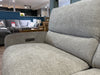 Close-up of a light gray easy-clean fabric sofa armchair in a furniture store. Other sofas, tables, and decor items are visible in the background, including the Willow Corner sofa. A Sale sign can be seen on the left side.