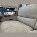 Close-up of a light gray easy-clean fabric sofa armchair in a furniture store. Other sofas, tables, and decor items are visible in the background, including the Willow Corner sofa. A Sale sign can be seen on the left side.