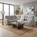 Modern living room with a large light-gray Avery Electric Recliner Corner sofa, rectangular coffee table, floor lamp, plants, abstract wall art, shelves with decor, and large windows with city views. Neutral tones and cozy, minimalist style are complemented by this electric recliner sofa for an enhanced entertainment experience.