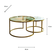 Introducing the Salzburg Nest: a set of two round coffee tables showcasing a refined nesting design with gleaming gold metal frames and sleek glass tops. The larger table measures 80 cm in diameter and 43 cm in height, while the smaller table tucks partially beneath for an elegant, space-saving arrangement. Ideal for modern interiors, Salzburg Nest effortlessly blends practicality with chic style inspired by marble and glass trends.