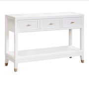 The Bali 3 Drawer Console is a white wooden console table featuring three drawers with gold handles, an open lower shelf, and tapered legs with gold accents—effortlessly bringing coastal-inspired style to your living space.
