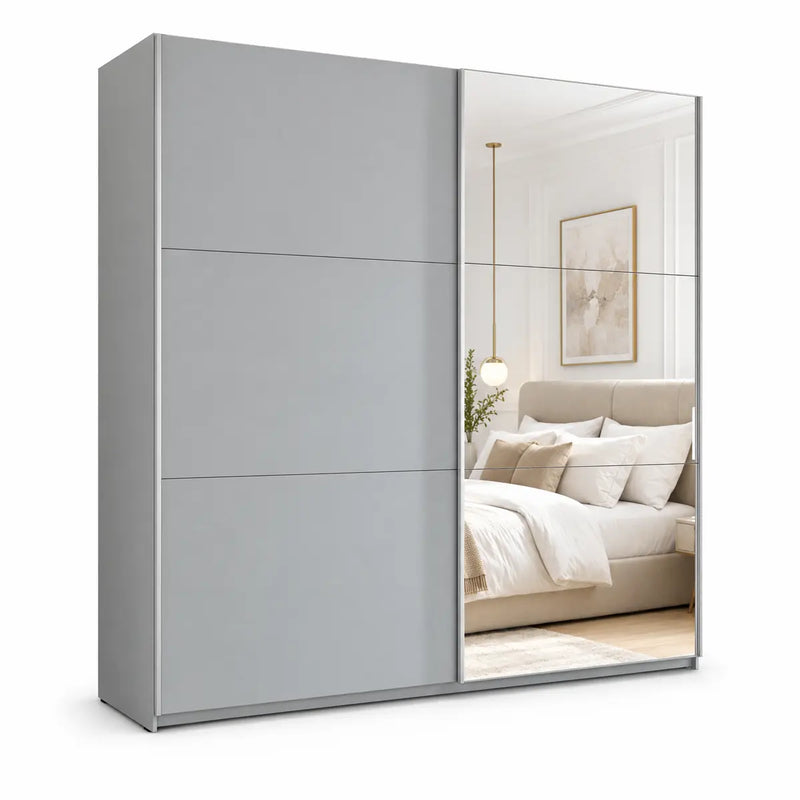 The Vigo Sliderobe, a gray wardrobe featuring one solid and one mirrored sliding door, reflects a modern bedroom complete with a bed, artwork, pendant light, and neutral decor.