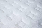 Close-up of the Respa Serene Gel Mattress surface, showcasing a white, quilted texture with intricate, raised designs and gentle, curved indentations—expertly crafted with moisture-wicking materials to help keep you cool and comfortable all night long.