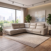 Contemporary beige leather Chloe Corner Group sectional sofa with a chaise lounge positioned on a textured area rug in a room with large windows.