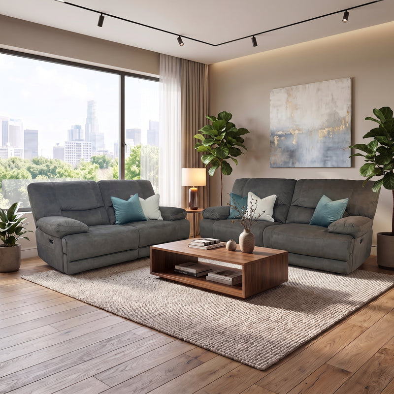 Two grey Gibson Electric Recliner sofas with blue and white throw pillows arranged around a wooden coffee table in a bright living room.