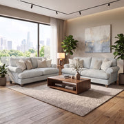 Two light gray Monroe Sofa Range sofas face each other over a wooden coffee table on a textured area rug in a room with a large window overlooking a city skyline.