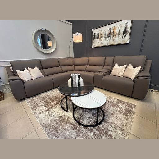 A modern living room features the Vegas Corner Group in wipeable gray fabric, five white pillows, two round coffee tables, a floor lamp, a round mirror, and running horse wall art on a dark accent wall.
