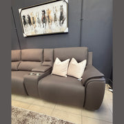 The Vegas Corner Group, a modern gray wipeable fabric sofa with two light-colored throw pillows, sits against a dark wall beneath a framed painting of running horses, with a carpet partially visible on the tiled floor.