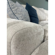 Close-up of the Grand Corner Group 4L, a light gray modular sofa with micro pocket springs for comfort, neatly arranged with two blue and one gray herringbone-patterned cushions.