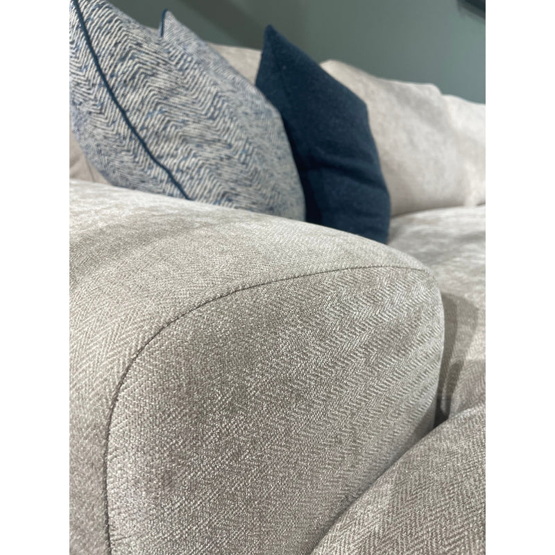 Close-up of the Grand Corner Group 4L, a light gray modular sofa with micro pocket springs for comfort, neatly arranged with two blue and one gray herringbone-patterned cushions.