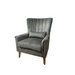 The Charlotte Chair is a comfortable dark gray upholstered accent chair with a high channel-tufted back, wooden legs, and a matching lumbar cushion, shown against a plain white background.