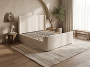 Azure Bedframe, a contemporary upholstered bed with a wingback headboard and wooden slats in a neutral bedroom.