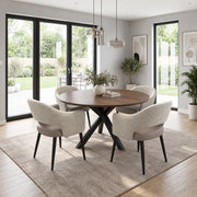 The New York Round Table is a walnut extending dining table with a round top and black crisscross base, surrounded by four upholstered chairs with curved backs.