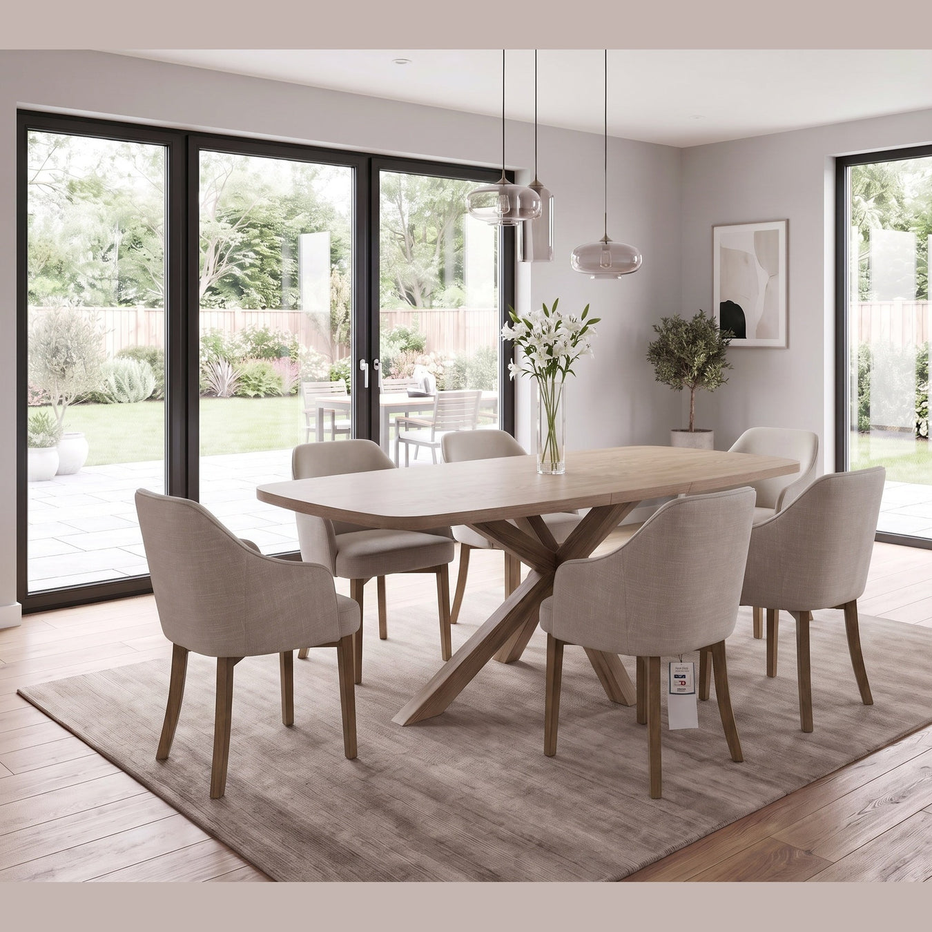 Ashton Dining Table in solid ash wood featuring an oval top and cross-base, surrounded by six upholstered chairs with wooden legs.