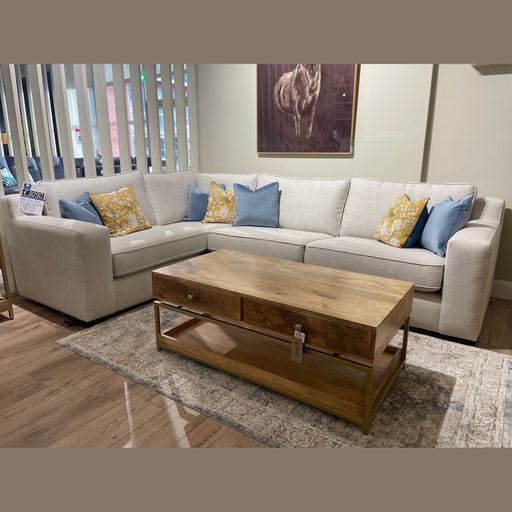 The Alice Corner Group, a made-to-measure beige sofa with blue and yellow patterned cushions, is arranged around a wooden coffee table on a light rug, with horse wall art above it in this modern living room.