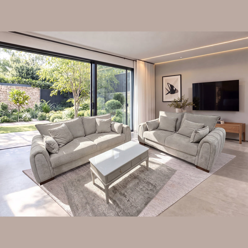 A matching Berkley 3+2 - Special Offer stone fabric sofa and loveseat set facing a white coffee table in a modern living room with large sliding glass doors opening to a garden.