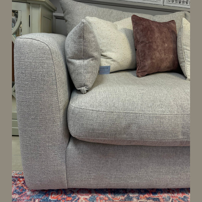 A close-up of the Casablanca Corner Sofa in light gray aqua clean fabric with deep seats, styled with brown and beige cushions on a colorful rug. A £2999 price sign appears in the background alongside ornate wall decor.