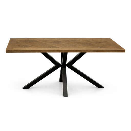 The Hugo Dining Table features a contemporary wood veneer tabletop and black metal legs in an X-shape, pictured against a white background.