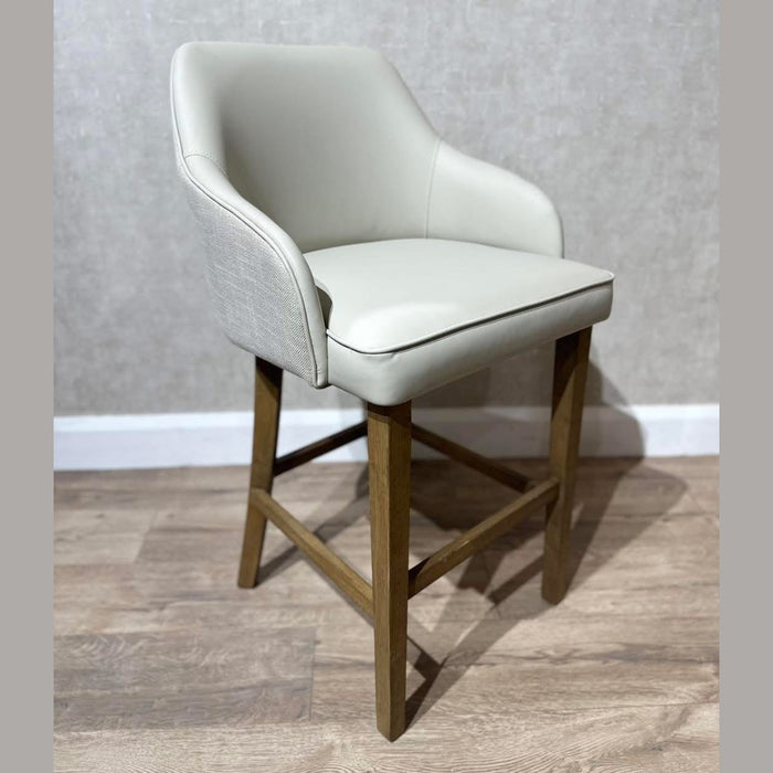The Como Counter Stool showcases a light beige cushioned leatherette seat and backrest, wooden legs, and footrest—delivering a sleek, modern look perfect for any space.