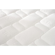 Close-up of the King Koil Spinal Guard (ICA) mattress by vendor-unknown, showing a white, textured quilted surface with rectangular and oval patterns. The cushioned fabric suggests comfort and optimal posture support.