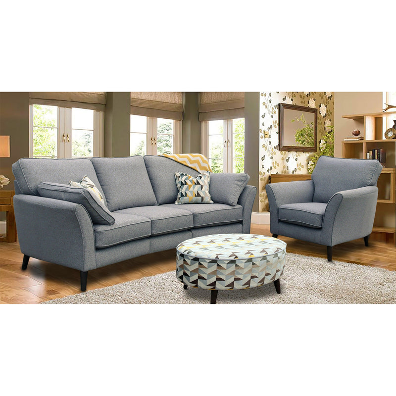 A modern gray fabric Angle seatee with a full range of aquaclean fabrics, featuring a sofa and an armchair set in a living room setting with a patterned ottoman in the foreground.