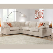 The Dexter Corner sectional by vendor-unknown, in beige with orange floral pillows, is arranged in a bright living room with a beige rug, glass side tables, a modern floor lamp, floral wall art, and light from large windows.
