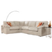 The Dexter Corner is a modern beige corduroy corner sofa, paired with two orange patterned throw pillows, a glass side table with a brown vase, and a curved floor lamp in the background.