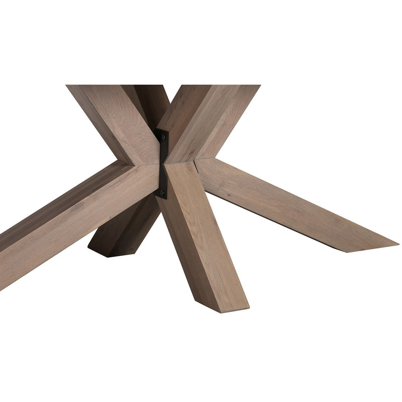 Close-up of the Marlo Dining Table by vendor-unknown, featuring a spider leg base with four thick, angled, light brown wooden legs meeting at a central metal bracket and an X-shaped support for a unique look.