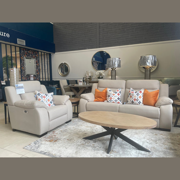 Modern living room display featuring a beige sofa with colorful pillows, Lorenzo Electric Recliner Sofas, a round wooden coffee table, metallic-shade lamps, wall mirrors, and a light patterned rug on tiled flooring.