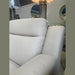 A close-up view of a Lorenzo Electric Recliner Sofa in a furniture store, with stylish lamps and round mirrors behind it. The store’s name, “Finlay’s Furniture,” appears reflected in the background.