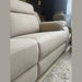 A close-up, angled view of the Lorenzo Electric Recliner Sofa in beige with plush armrests, set on a light tile floor by a textured rug. A large decorative vase and other furniture appear in the background.