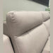Close-up of the Chloe 3+2 Electric Recliner Sofa in light beige washable fabric, featuring plush cushioned backrests and set against a pale wall, with a touch of green plant visible on the right.