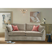 The Chantel Collection beige sofa by vendor-unknown, featuring aquaclean fabric and two pink pillows, sits in a modern living room with abstract wall art, a black floor lamp, round side table, magazine on wooden floor, and a contemporary chandelier overhead.
