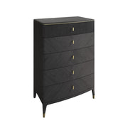 The Diletta Tall 5 Drawer Chest features a modern ribbed design with gold handles, subtle gold leg accents, and a textured top drawer. Tapered legs add elegance, all set against a white background for contemporary style.