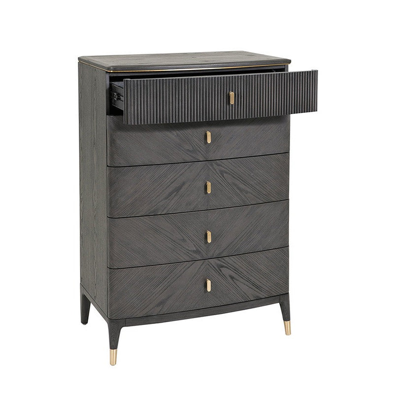 The Diletta Tall 5 Drawer Chest features a dark wood finish, ribbed drawer fronts, gold handles, and tapered legs with gold caps. The partially open top drawer reveals its ribbed texture, adding elegance to this versatile storage piece.
