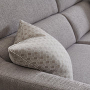 A close-up of the Otis Sofa Range in light gray aquaclean fabric features a beige and white geometric patterned cushion resting against the armrest.