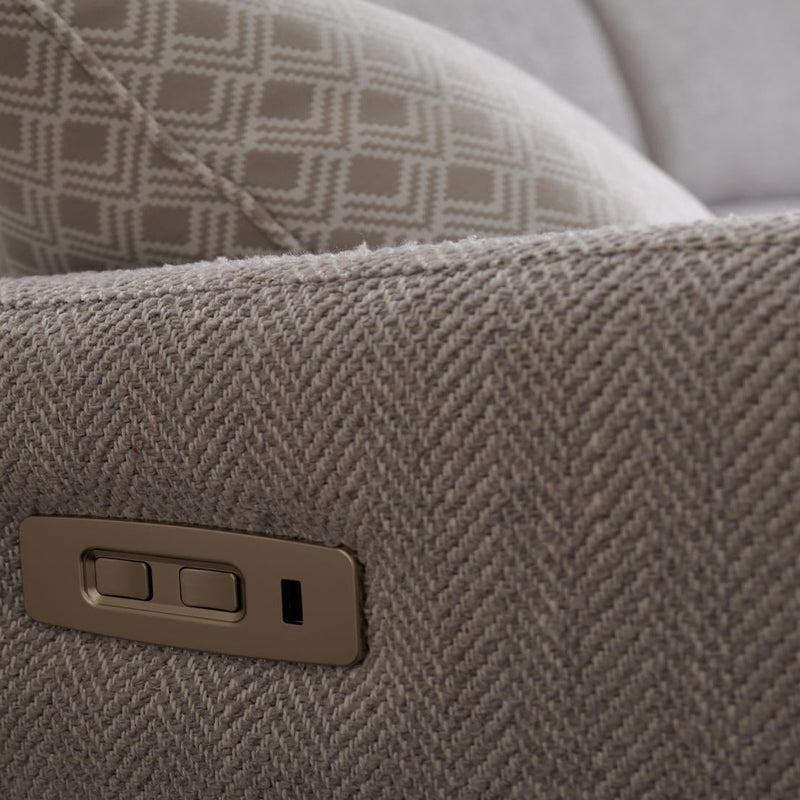 Close-up of a textured beige Aquaclean fabric armrest on the Otis Sofa Range, featuring an embedded two-button control panel. In the background, a pillow displays a geometric diamond pattern.