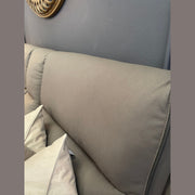 A close-up shows the light gray, textured backrest of the Vegas Corner Group sofa with two white pillows against it, set by a gray wall. A gold-framed mirror appears partially in the top left corner.