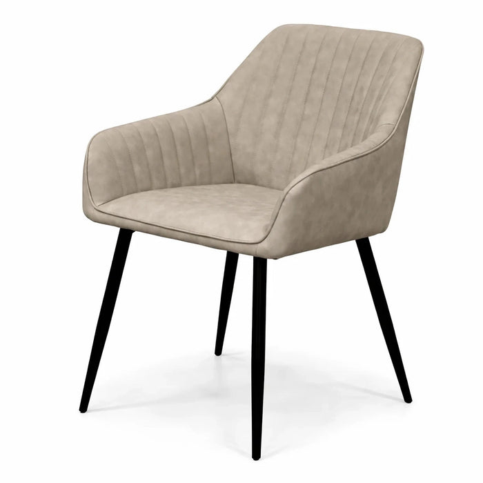 The Enzo Dining Chair is a modern beige suede seat with a curved back, armrests, vertical stitching, and four slim black metal legs, shown against a white background.