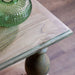 A close-up of the Marwood Coffee Table corner with a turned leg, topped with a green textured glass vase. Its natural wood finish highlights the grain and knots. Dimensions: 120 cm wide, 45 cm high.