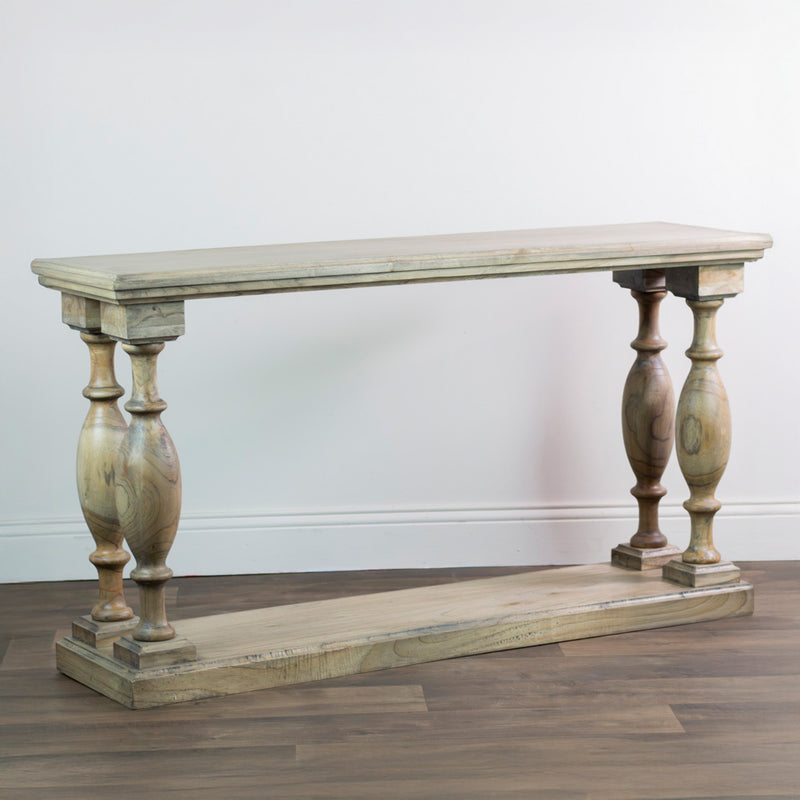 The Marwood Large Console Table features a natural finish, rectangular top and bottom shelf, and four decorative turned legs. Measuring 150 cm wide and 82 cm high, it stands on a wooden floor against a plain white wall.