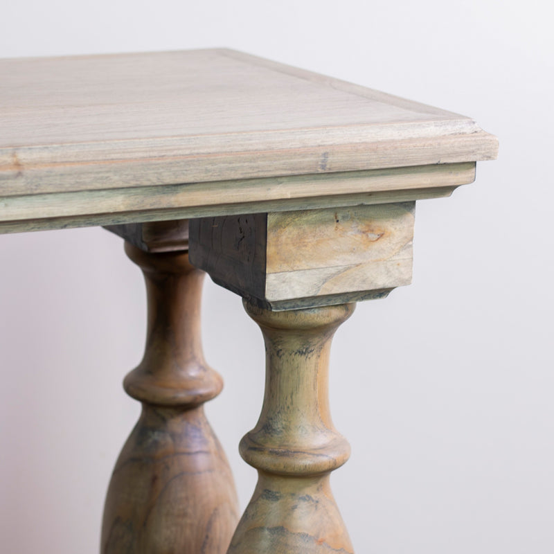 A close-up of the Marwood Large Console Table’s corner shows carved legs and a natural, unfinished wood look against a plain background; dimensions: width 150 cm, height 82 cm.