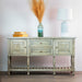The Marwood Large Sideboard Console (150 cm wide, 82 cm high) features two cabinets and two drawers, topped with a green vase of pampas grass, a white lamp, and yellow boxes, set against a light wall on wooden flooring.