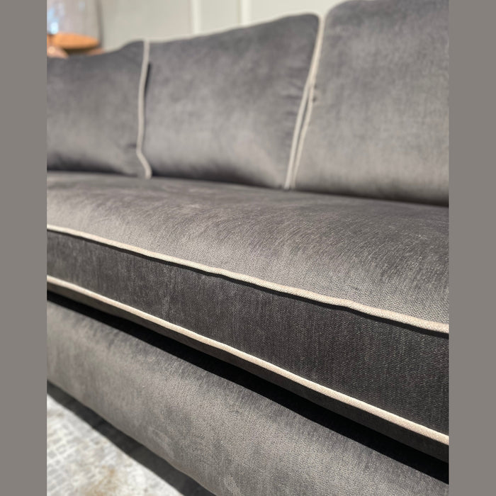Close-up of the Emperor Range suite in modern gray velvet with light piping, plush seats and backrest. Upholstered in durable Aqua Clean fabric, this Irish-made suite is elegantly displayed under soft indoor lighting.