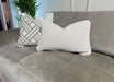 The Opus Chaise is a gray upholstered, contemporary modular sofa featuring two decorative pillows—one geometric and one textured beige—and pairs beautifully with greenery for a fresh, modern vibe.