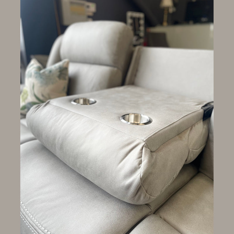 A close-up of the light gray Reno Recliner Sofa armrest with two built-in cup holders. A botanical-pattern pillow in the background highlights the stylish comfort and washable fabric of this 3 seater.