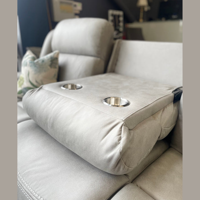 A close-up of the light gray Reno Recliner Sofa armrest with two built-in cup holders. A botanical-pattern pillow in the background highlights the stylish comfort and washable fabric of this 3 seater.